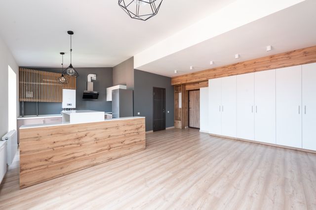 spacious minimalist kitchen with wood accents and white cabinets